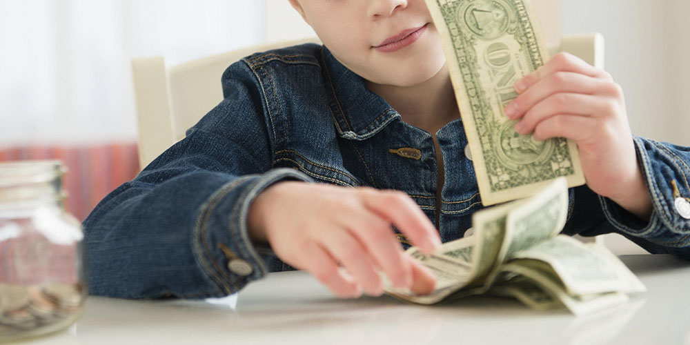 Boy counting a bundle of banknotes