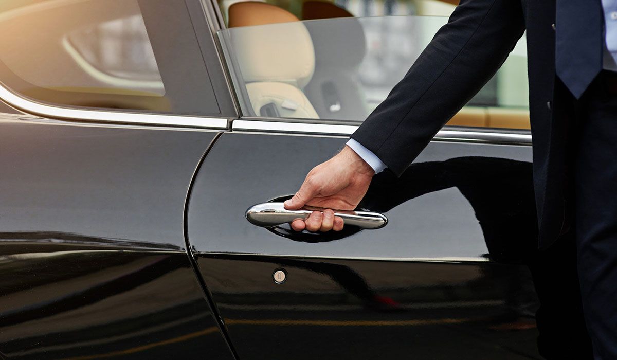 Chauffeur holding the car door handle