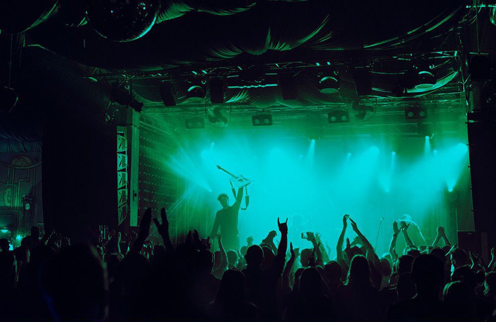 Cheering crowd having fun at music festival in a nightclub