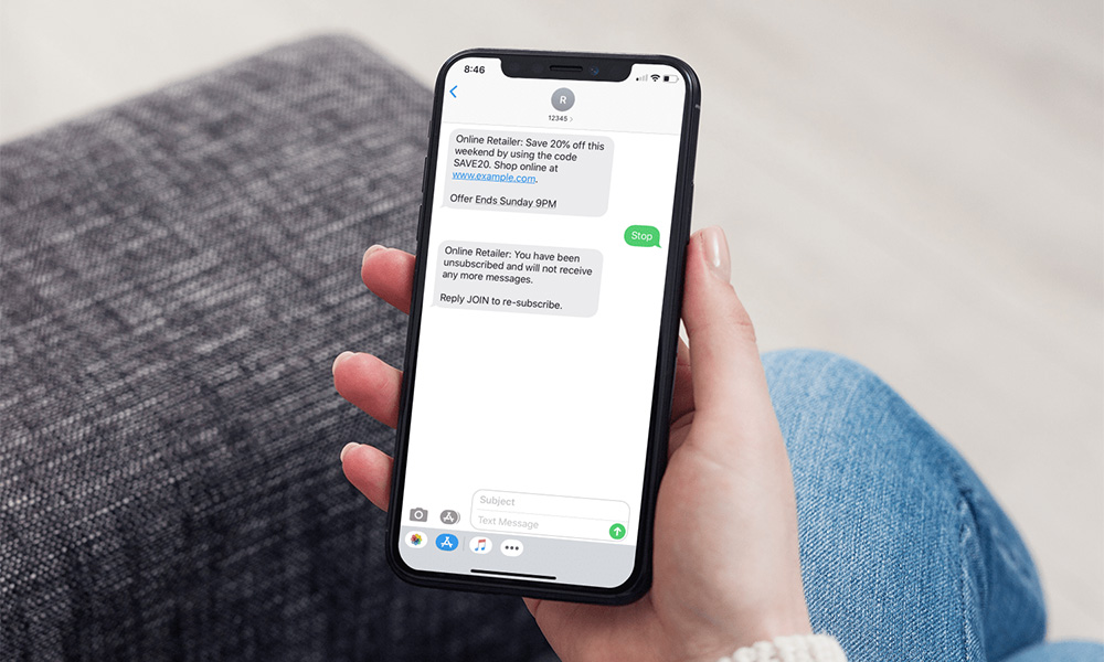 Close up of a phone held by a woman sitting on the couch