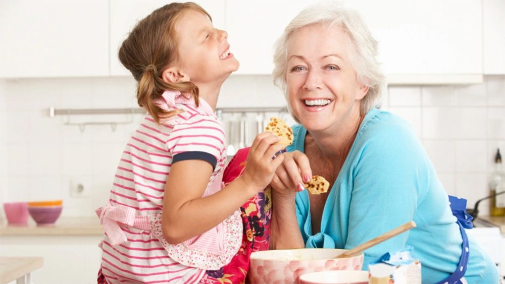 Grandmother with granddaughter eating homemade cookies