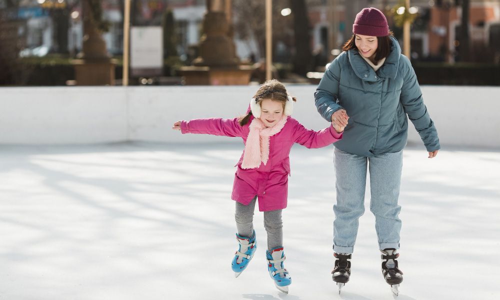 Mother with daughter on the ice rink