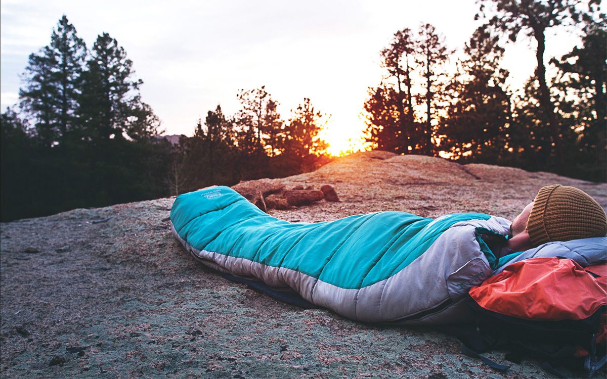 Person in sleeping bag watches the sunset