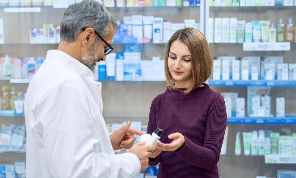Pharmacist helping woman medicine choice
