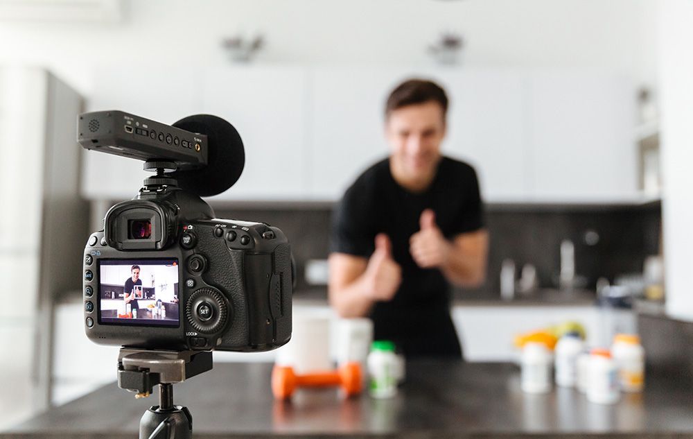 Smiling young man filming his video blog episode