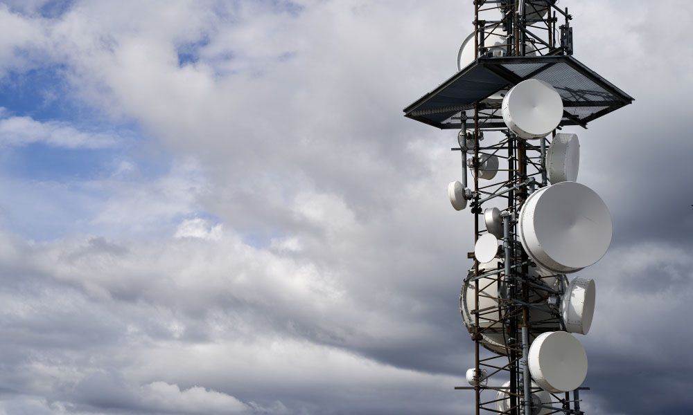 Telecommunications towers against cloudy sky