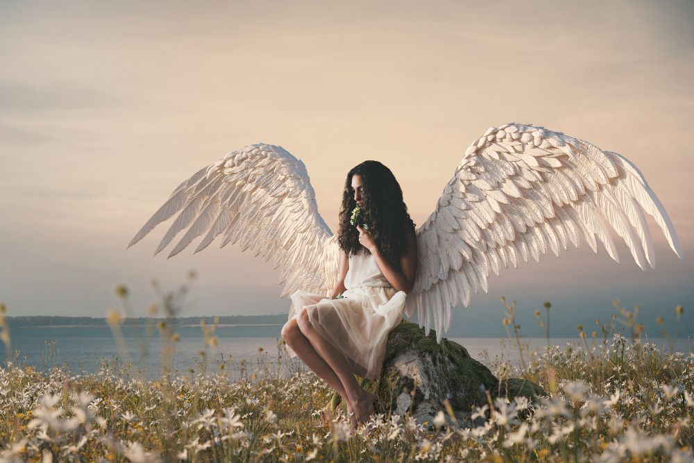 Woman angel sitting on stone