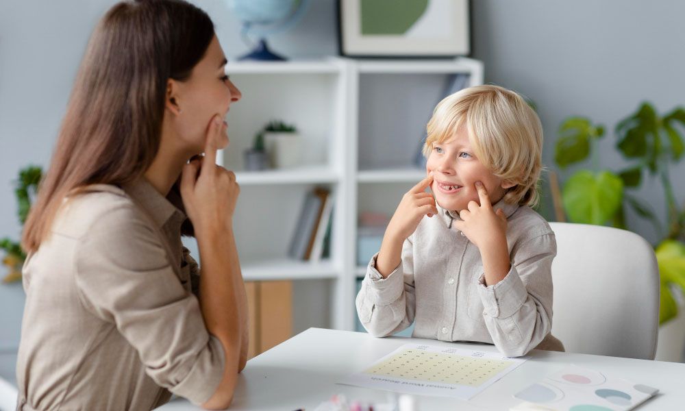 Woman doing speech therapy with a little blonde boy