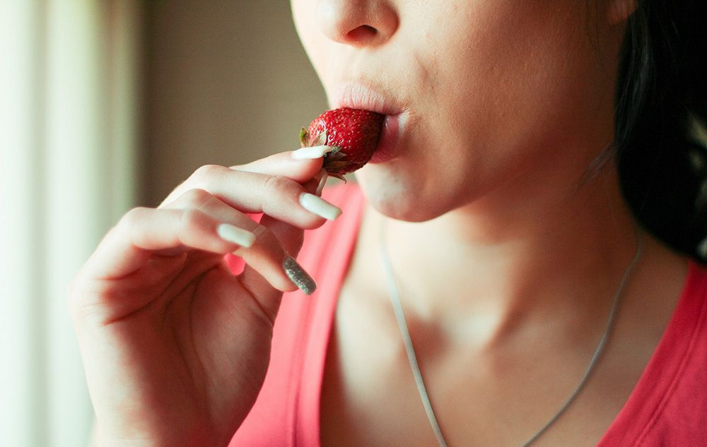 Woman eating strawberry